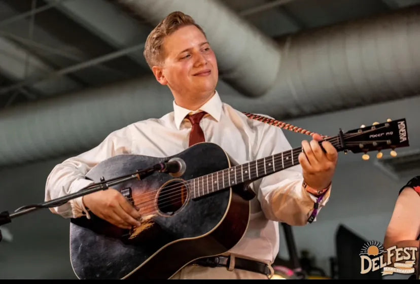 Conner Vlietstra playing a flattop guitar on stage, performer at Bristol Sessions Nights: The Blue Yodel in Bristol, Tennessee