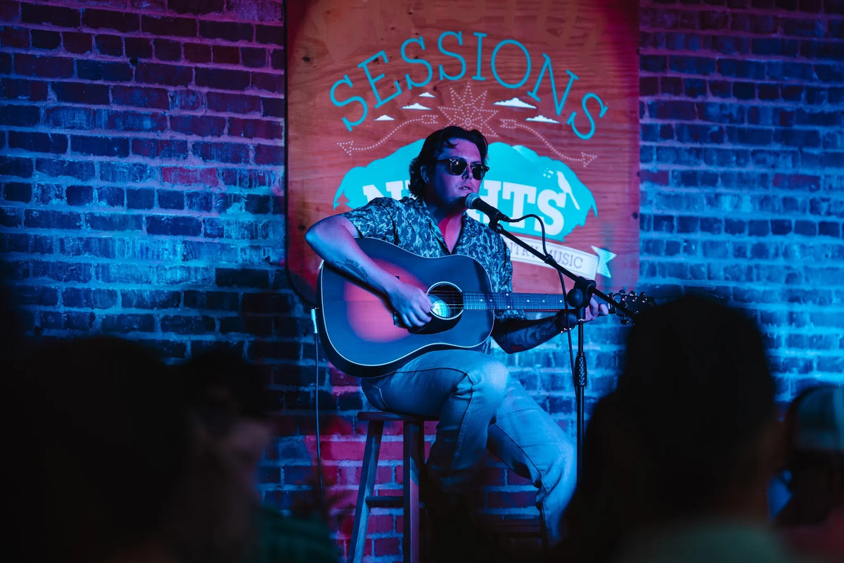 Chance Lawson singing with an acoustic guitar under blue stage light at Bristol Sessions Nights: The First Take, Bristol Listening Room, L.C. King Building, Bristol, Tennessee