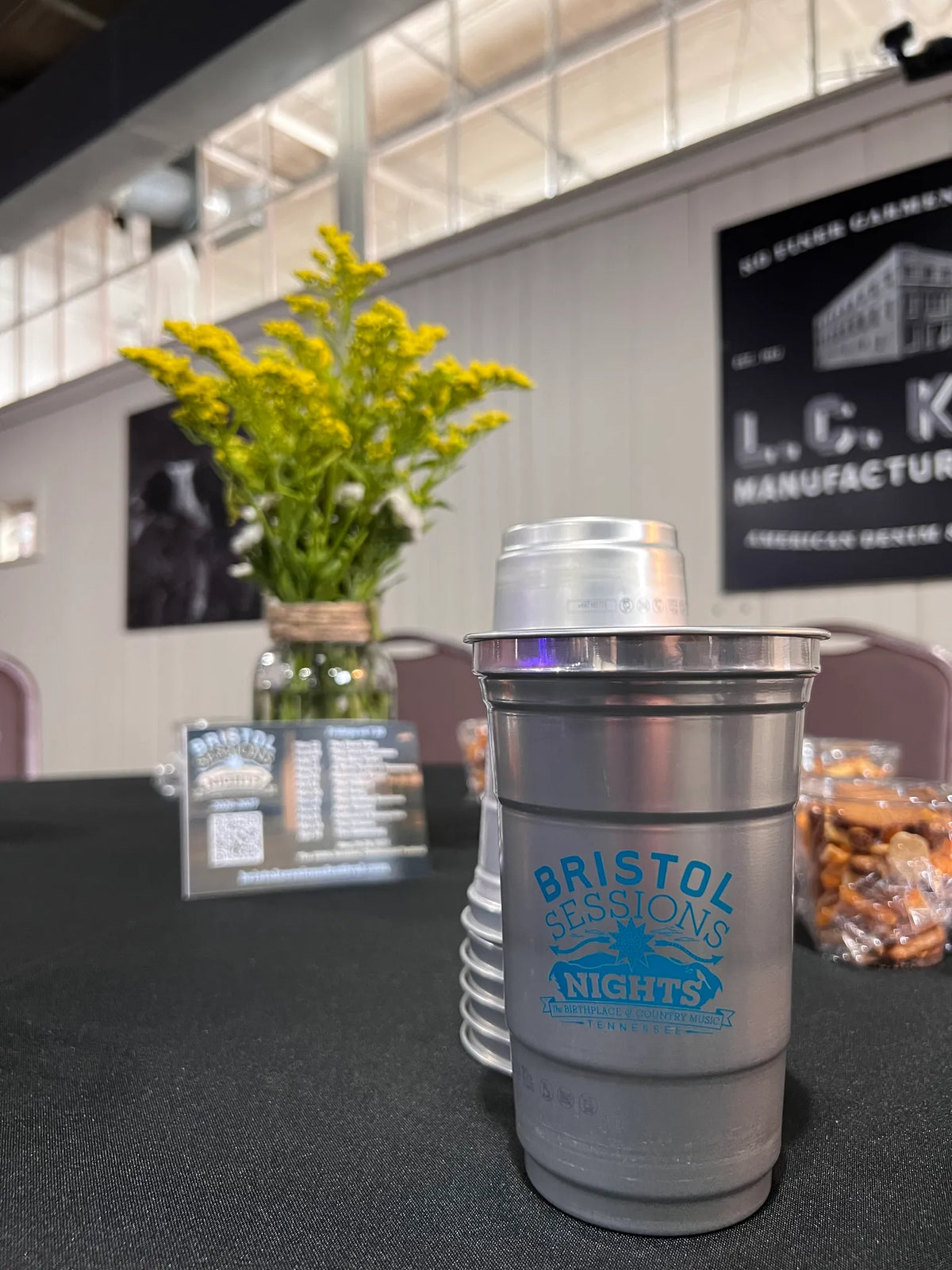 Bristol Sessions Nights branded aluminum cups and a goldenrod centerpiece on a guest table at Bristol Sessions Nights: The First Take, Bristol Listening Room, L.C. King Building, Bristol, Tennessee