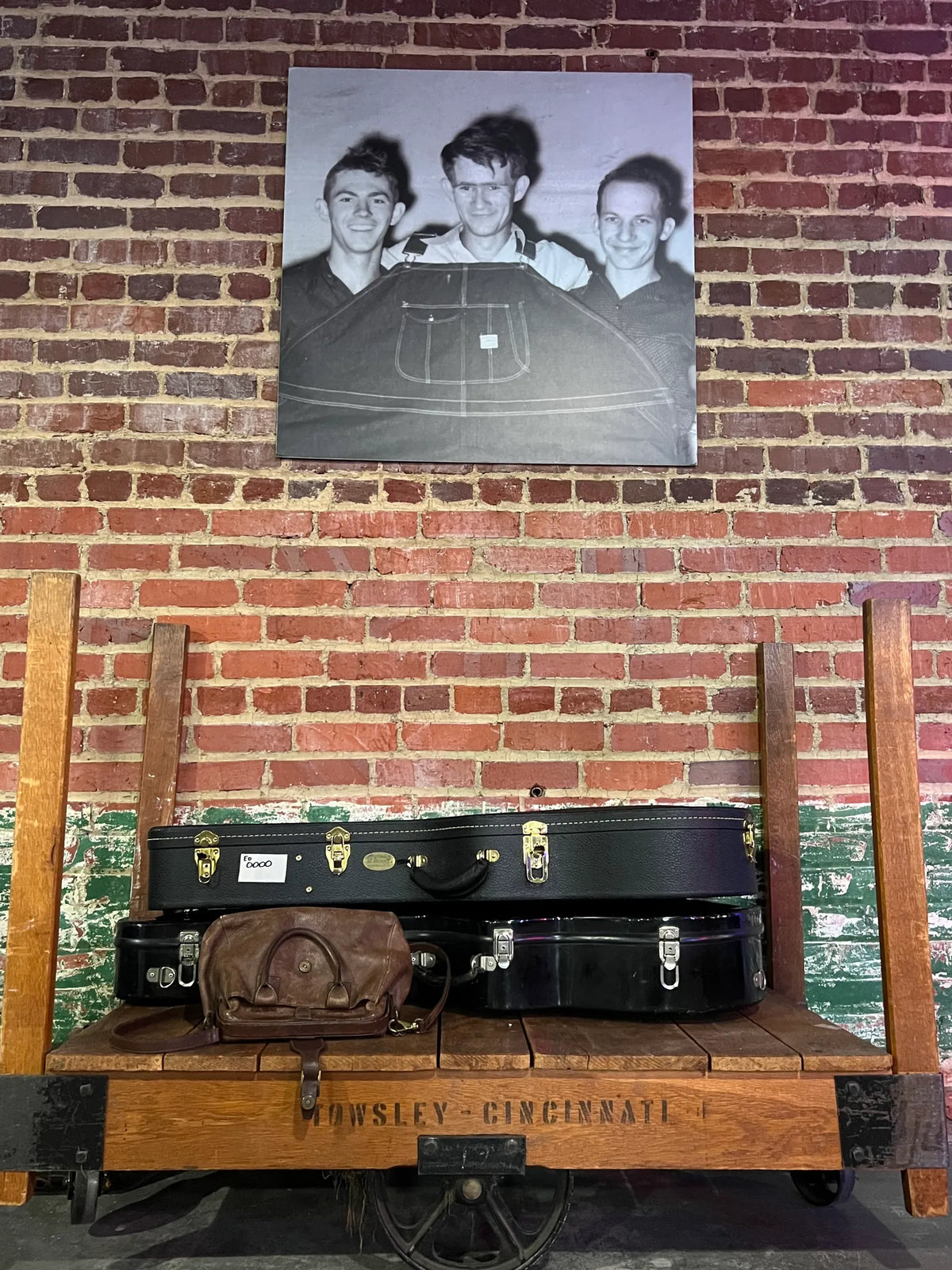 Vintage guitar cases on an antique cart beneath a historic black-and-white photo at Bristol Sessions Nights: The First Take, Bristol Listening Room, L.C. King Building, Bristol, Tennessee
