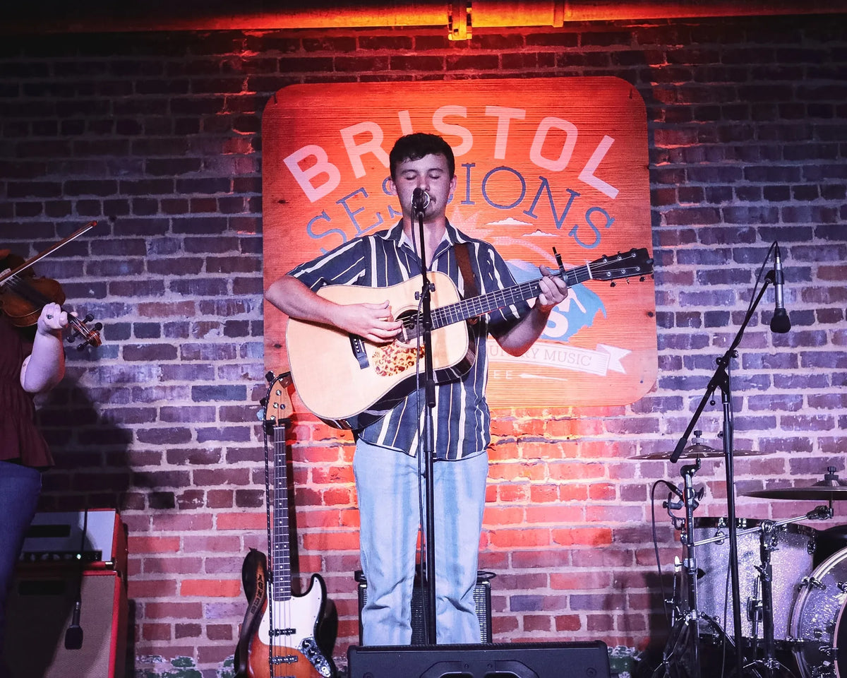 Ryder Casey performing in front of the Bristol Sessions Nights sign at Bristol Sessions Nights: A True Taste of Tennessee, Bristol Listening Room, L.C. King Building, Bristol, Tennessee